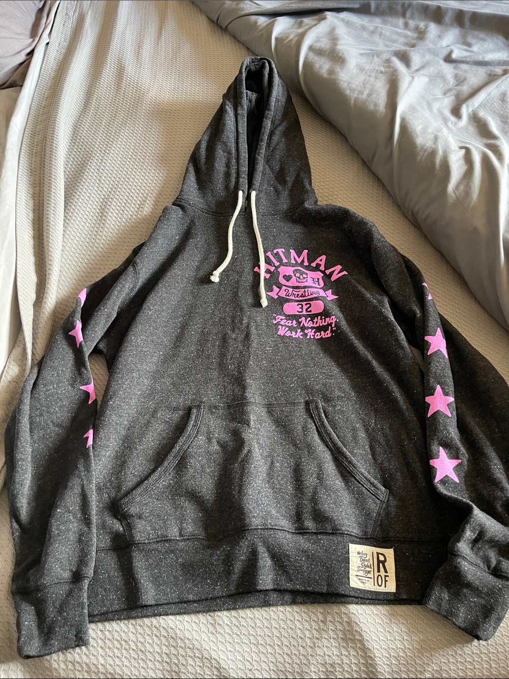 Roots of Fight 
Hitman Black Hoodie with Pink Stars
Bret Hart